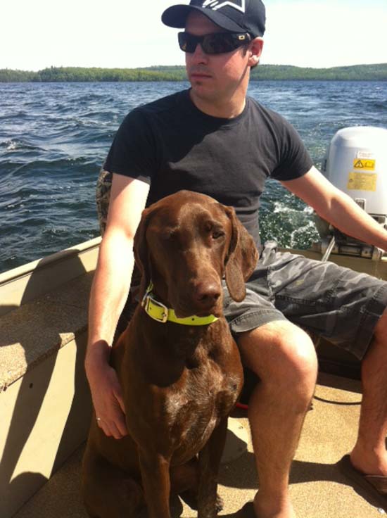 A Fogelhund German Shorthaired Pointer on a boat with its owner.